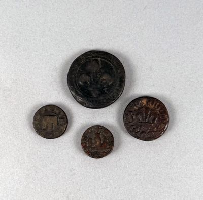 trois vieilles pièces de monnaie posées les unes à côté des autres sur une surface blanche