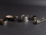 five silver cups and spoons on a black surface