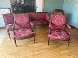 plusieurs chaises dans une pièce dotée d'un parquet et d'un mur tapissé