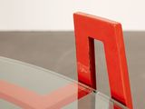 a red chair that is sitting on a glass table