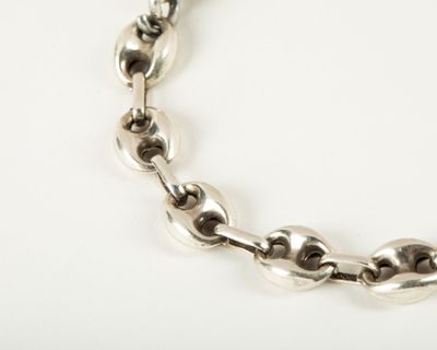 an image of a close up of a chain bracelet on a white surface
