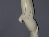 statue représentant un oiseau posée sur un socle, sur une surface grise