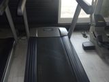 un tapis de course dans une salle de sport, avec une fenêtre en arrière-plan