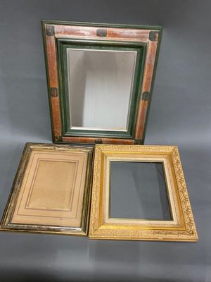 three different colored frames are sitting next to each other on a gray surface