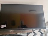 a flat screen tv mounted on the wall above a stove