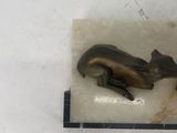 a bronze statue of a cat laying on a marble block