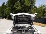 a car with its hood open sitting on a brick road