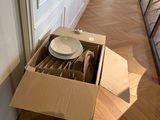 a cardboard box with a plate inside of it on the floor