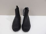 a pair of black leather ankle boots on a white surface