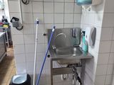 a bathroom with a sink and a mop on the floor
