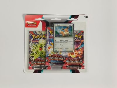 Deux cartes Pokémon se trouvent dans un paquet posé sur une surface blanche