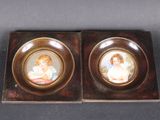pair of miniature porcelain portraits of children in a wooden box