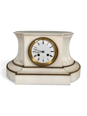 a white clock that is sitting on a table