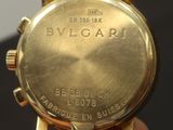 a person holding a gold watch in their hand