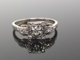 a close up of a diamond ring on a reflective surface