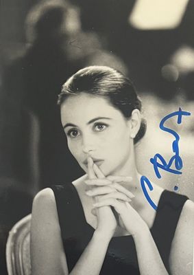 une vieille photo d'une femme assise à une table, une cigarette aux lèvres