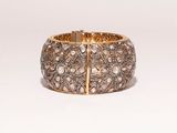 a close up of a gold and diamond bracelet on a white background