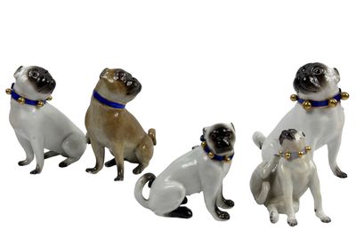 quatre figurines de chiens portant un collier et une clochette autour du cou