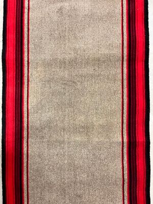 a red and beige rug with black stripes on a white background
