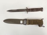 pair of military knifes with sheath and sheath on white surface