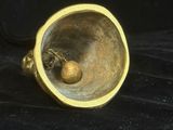 une bague en or avec une boule à l'intérieur, posée sur un tissu noir