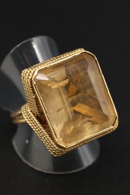 Gros plan sur une bague contenant une pierre jaune