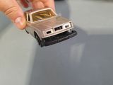 a person holding a toy car in front of a row of toy cars