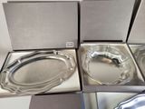three silver trays in a box on a white table