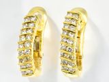une paire de boucles d'oreilles créoles en or jaune et diamants sur fond blanc