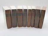 six livres sont alignés sur une surface blanche
