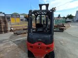 a red forklift truck parked in a parking lot