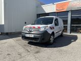 La camionnette est garée devant un immeuble sur le côté duquel est accrochée une pancarte.