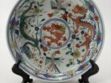 une image représentant une assiette ornée d'un dragon, posée sur un socle