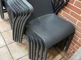 a lot of chairs that are lined up against a brick wall