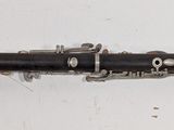 a black and silver clarinet on a white surface