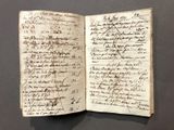 un vieux livre écrit posé sur une table