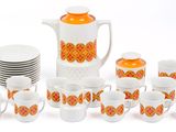 many cups and a pitcher with orange designs on them