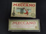 two boxes of mecano are sitting on a black surface