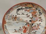 two plates with asian designs on them sitting next to each other
