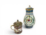 a small pitcher and a small cup sitting next to each other