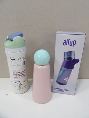 une bouteille et un récipient posés sur une table à côté d'une boîte