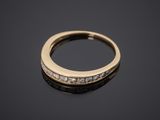 a yellow gold ring with diamonds on a black surface