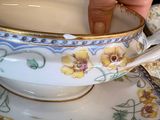 a person that is holding a spoon in a tea cup