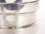 a silver container with a black handle on top of it