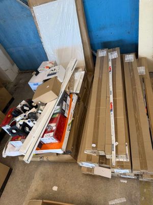 une pile de cartons posée par terre à côté d'une porte bleue