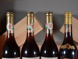 four bottles of wine are lined up on a table