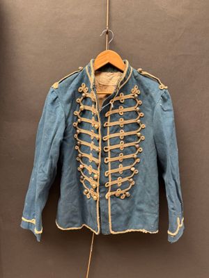 une vieille veste militaire bleue accrochée à un crochet fixé au mur