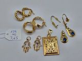 Plusieurs bijoux en or sont exposés sur un fond blanc