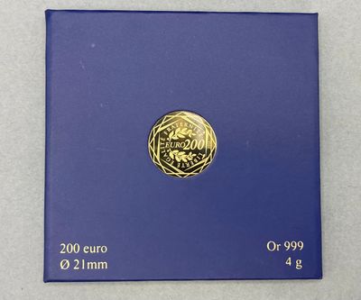 un gros plan d'une pièce d'or posée sur une boîte bleue