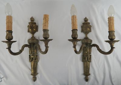 pair of antique brass wall sconces with candles on each of them